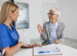 Young woman doctor or GP in white medical uniform consult senior female patient in private hospital. Female therapist speak talk with woman client on consultation in clinic.