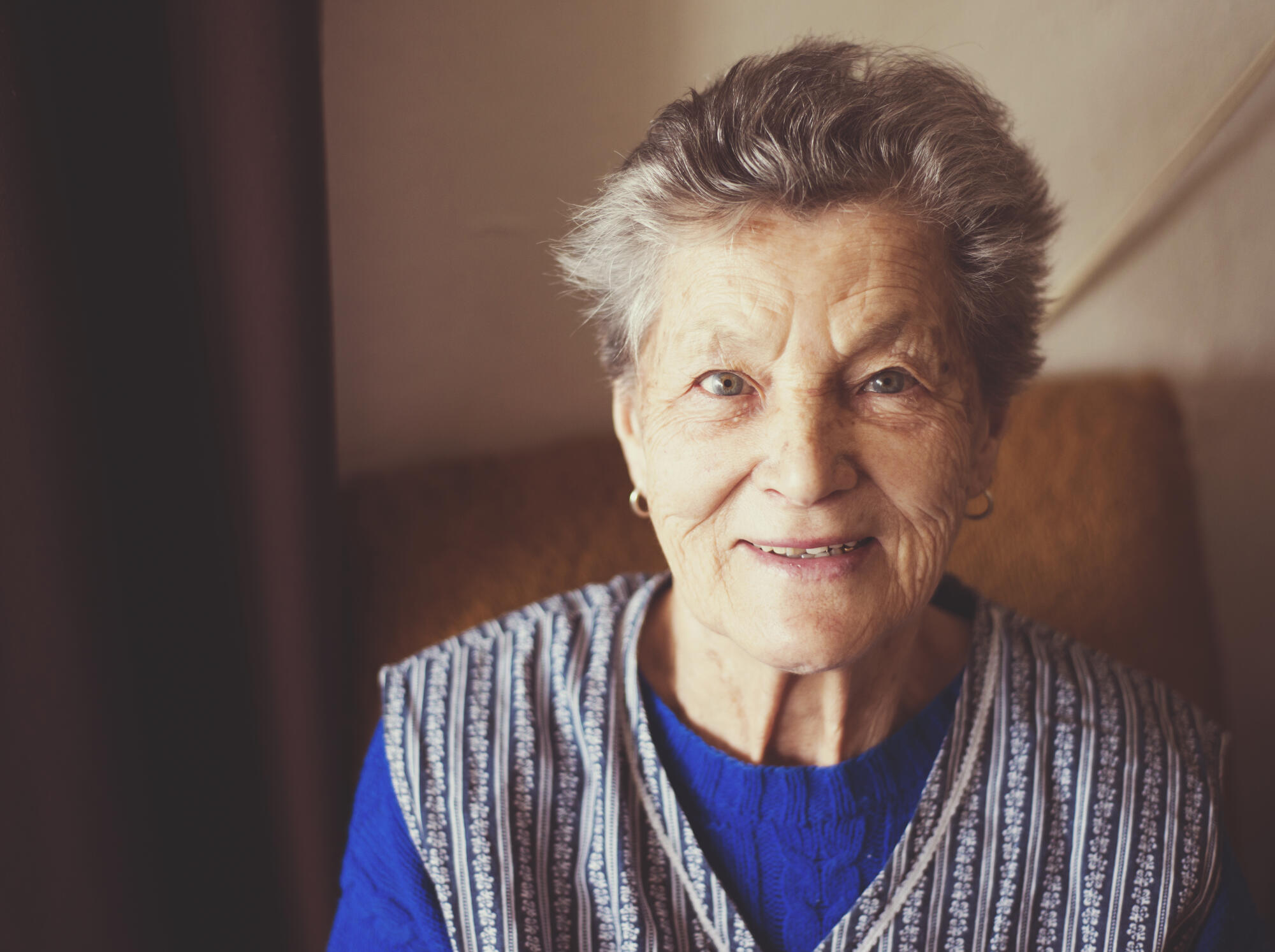 Portrait,Of,Senior,Woman,Sitting,In,Armchair,At,Home