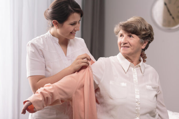 Helpful,Young,Caregiver,Giving,The,Sweater,To,Older,Woman