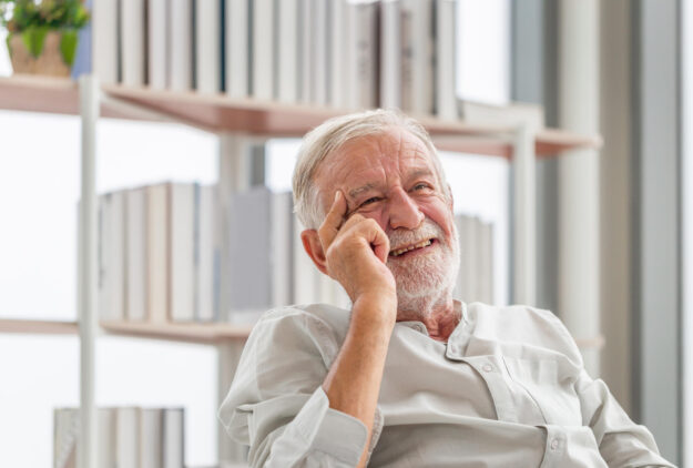 Portrait of smiling senior man relaxing and enjoying in living r Portrait of smiling senior man relaxing and enjoying in living r