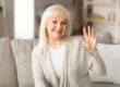 Mature woman waving at camera and smiling