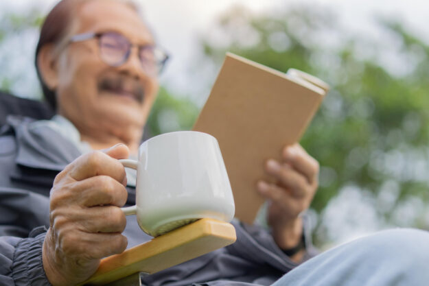 Close up hand of senior man holding a cup of coffee while restin Close up hand of senior man holding a cup of coffee while restin