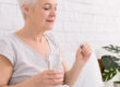 Senior Woman Taking Medication With a Glass of Water Indoors