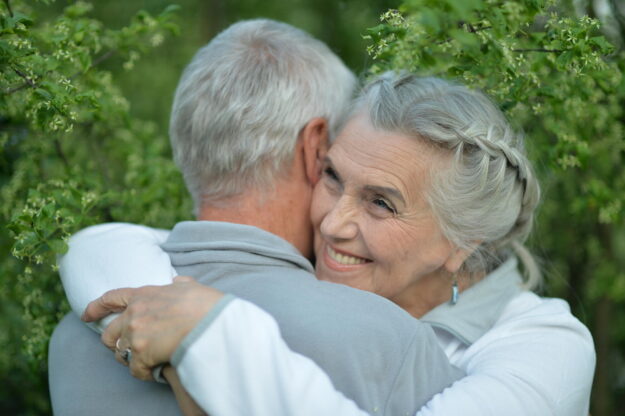 Beautiful elderly couple hugging in the park Beautiful elderly couple hugging in the park