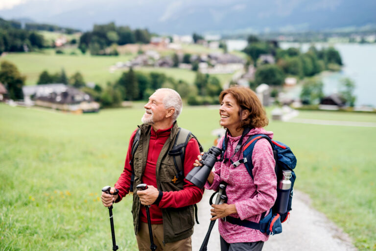 Senior,Pensioner,Couple,With,Nordic,Walking,Poles,Hiking,In,Nature.