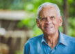 Portrait of smiling beautiful older male farmer. Elderly man at farm in summer day. Gardening activity. Brazilian elderly man.