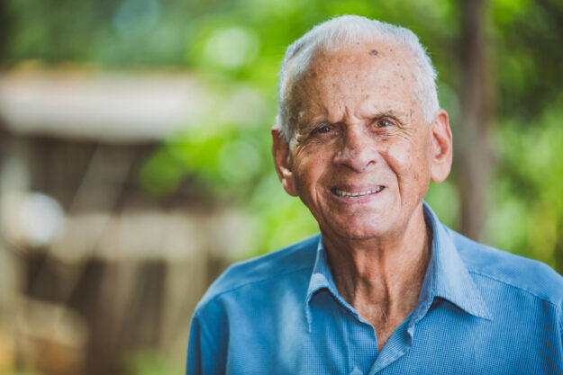 Portrait of smiling beautiful older male farmer. Elderly man at farm in summer day. Gardening activity. Brazilian elderly man. Portrait of smiling beautiful older male farmer. Elderly man at farm in summer day. Gardening activity. Brazilian elderly man.